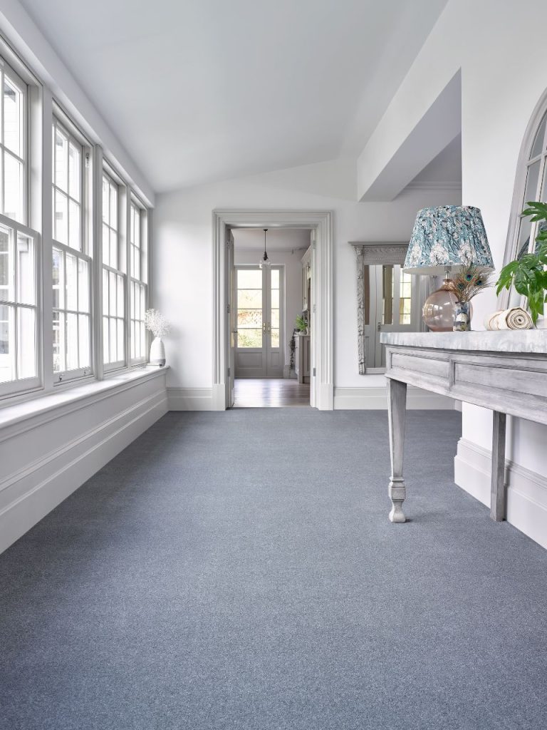 Photo shows hallway of a home with blue carpet | Carpet is available from Wall Bros Carpets in Worthing and Storrington