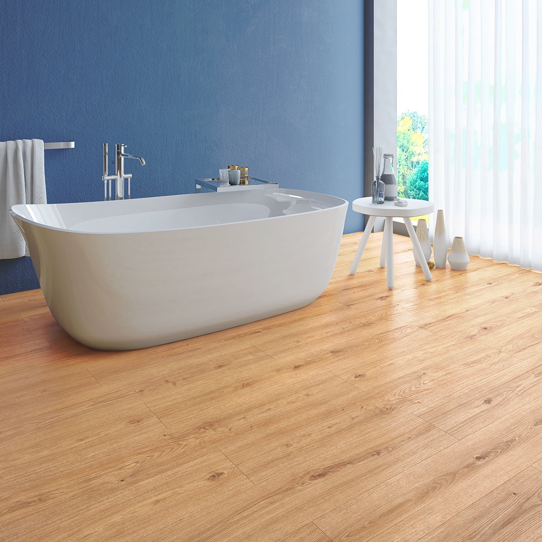 Photo shows a modern bathroom with a free standing bath. The flooring is beautiful wood-style laminate which is available at Wall Bros in Worthing and Storrington